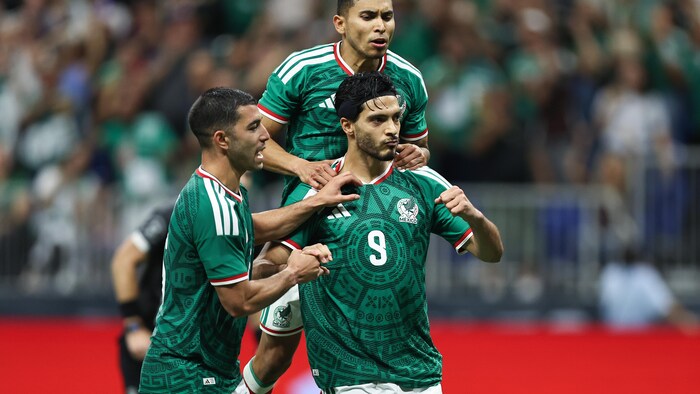 Des joueurs de soccer célèbrent un but.
