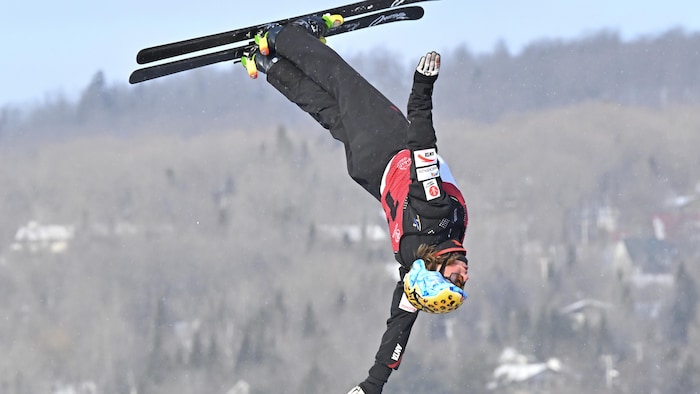Un skieur effectue une manœuvre dans les airs pendant un saut.