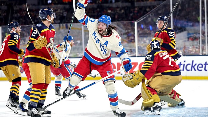Un hockeyeur sourit à pleines dents après avoir marqué un but.