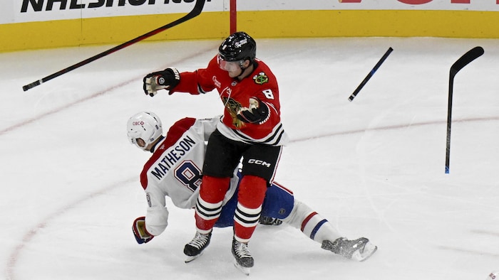 Deux joueurs de hockey entrent en collision et perdent leurs bâtons.