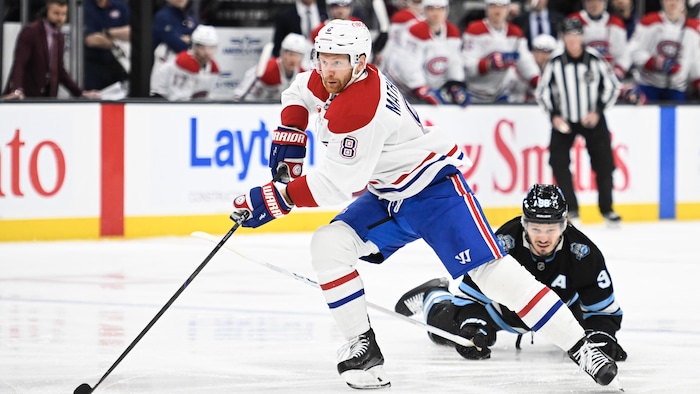 Un joueur de hockey patine avec la rondelle. 