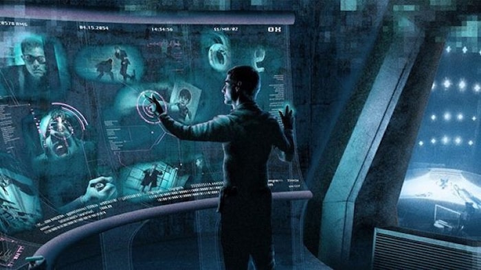 A standing man circulates information on a giant touch screen.