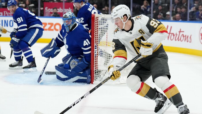Mitch Marner patine avec la rondelle autour du filet adverse. 