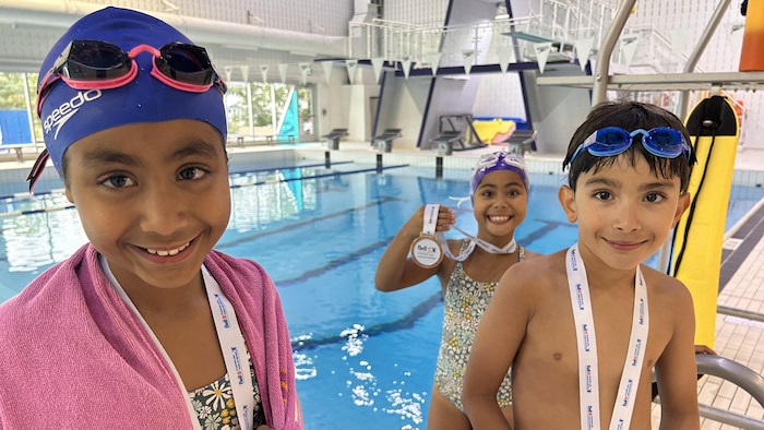 Trois jeunes à côté de la piscine