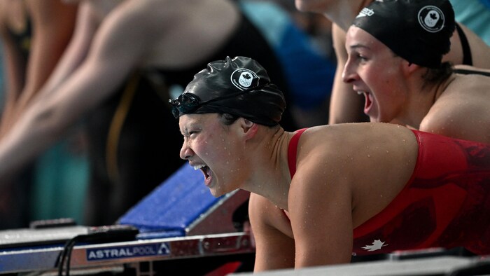 Elle crie sur le bord de la piscine après la victoire canadienne.