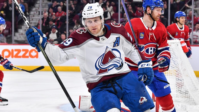 Le hockeyeur Nathan MacKinnon lève le bras droit pour célébrer un but.