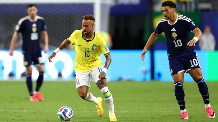 Un joueur de soccer court avec le ballon.