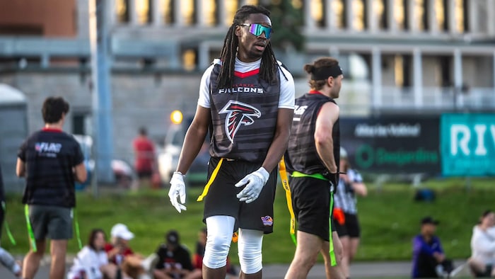 Un joueur de flag football tourne sa tête à sa gauche.