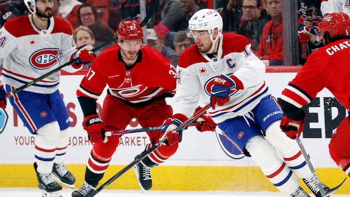 Un hockeyeur patine avec la rondelle.