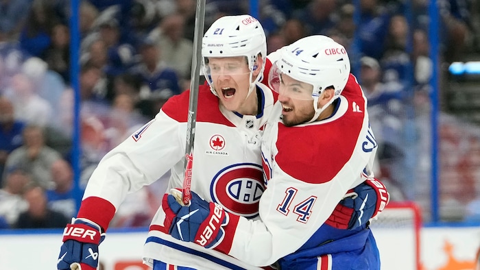 Deux joueurs célèbrent un but.