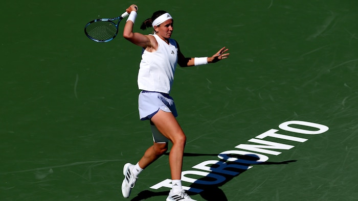 Une joueuse de tennis termine son élan.
