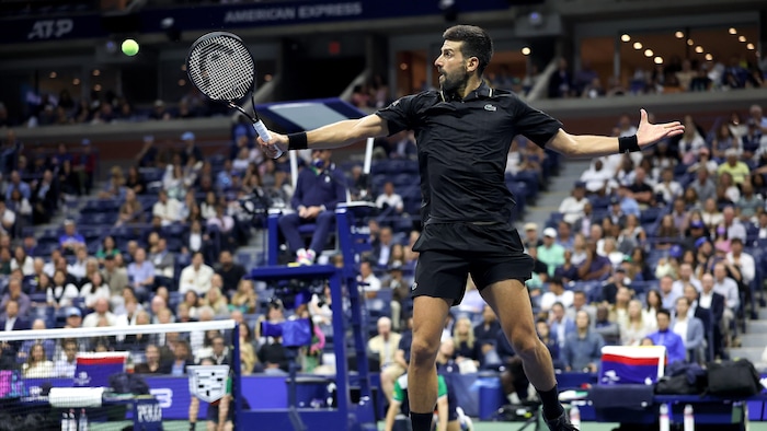 Un joueur de tennis frappe un revers.