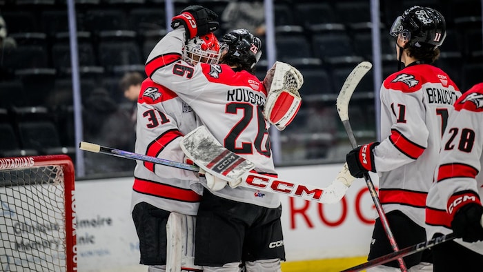 Des joueurs de hockey fêtent leur victoire.