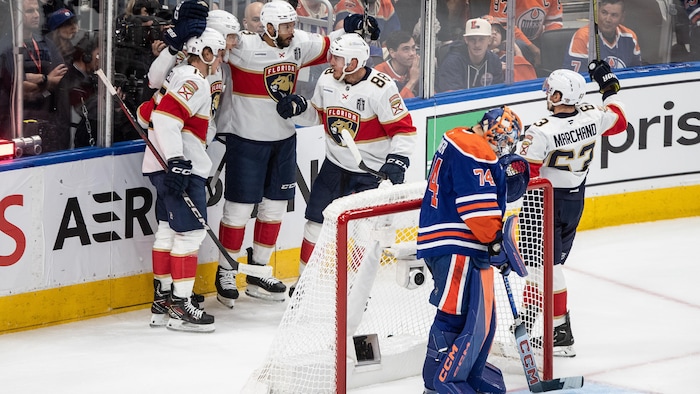 Les joueurs des Panthers célèbrent derrière le but des Oilers.