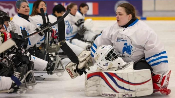 La gardienne se place en rang à côté de ses coéquipières sur la patinoire après un match.