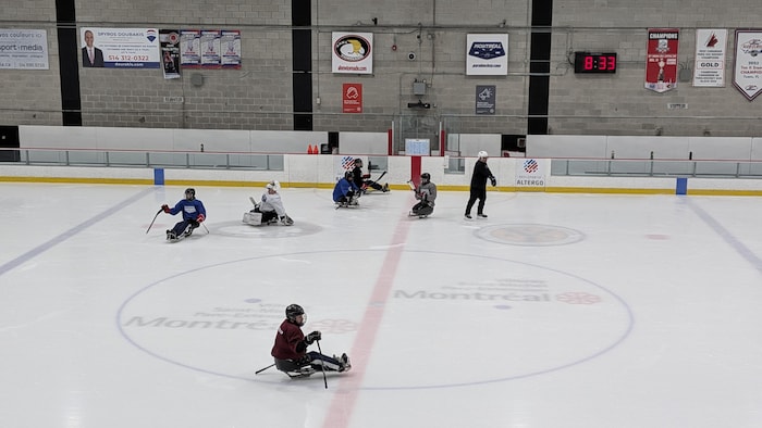 Des joueurs de parahockey au centre de la glace.