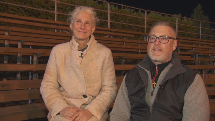 La mère et le père d'Ulrik assis dans les gradins en entrevue.