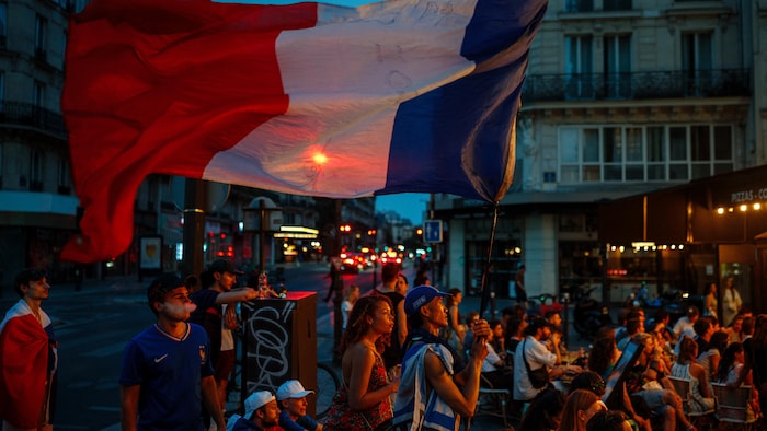 Des gens sont rassemblés pour regarder un match de soccer. 