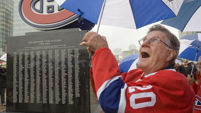 Souriant, il pose devant un monument du Canadien, vêtu de son ancien maillot.
