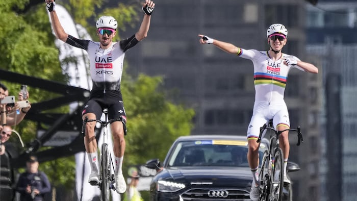 Deux cyclistes pédalent côte à côte.