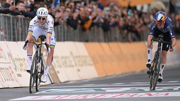 Tadej Pogacar lance son vélo pour battre au fil Tom Pidcock à l'arrivée de la course Milan-Sanremo.