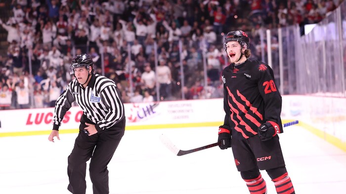 Joueur debout sur la glace, criant sa joie.