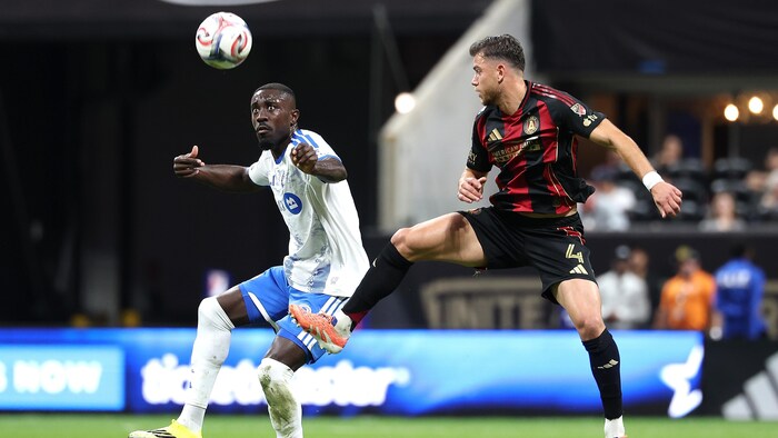 Deux joueurs de soccer se disputent le ballon.