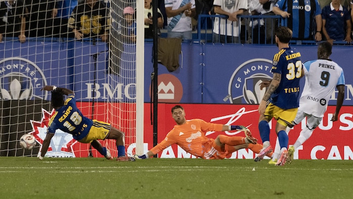 Un joueur de soccer tire le ballon et marque. 