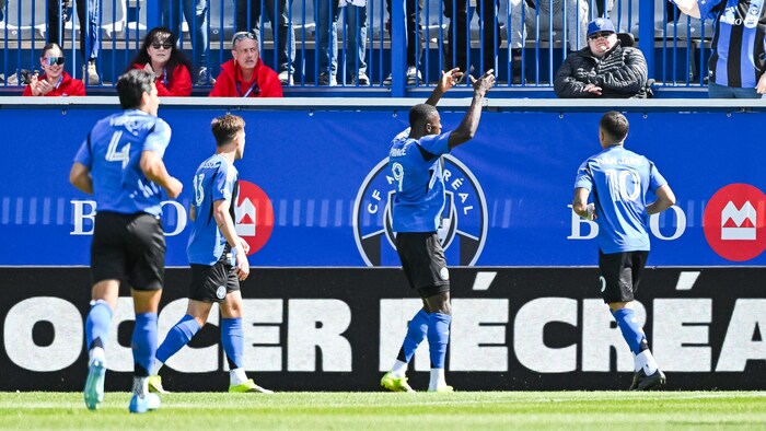 Des joueurs de soccer célèbrent un but.