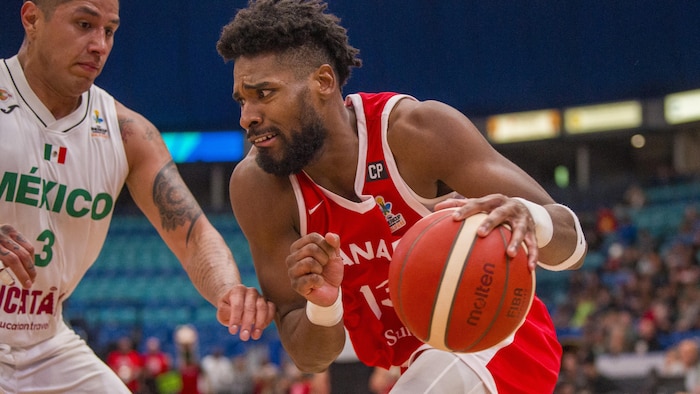 Un joueur de basketball drible avec le ballon. 