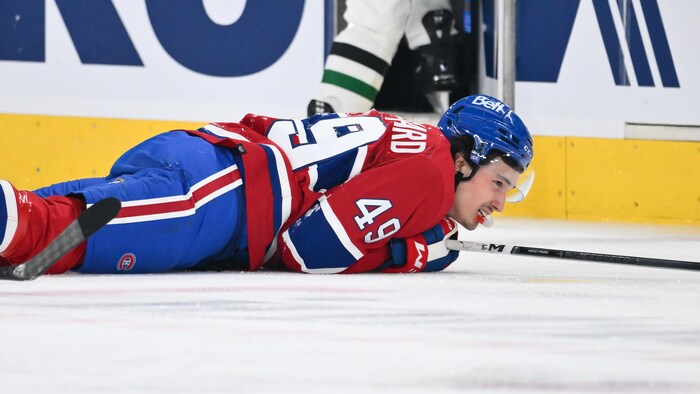 Un joueur de hockey est allongé sur la glace.