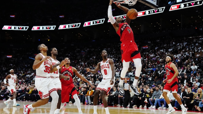 Un joueur de basket s'accroche au panier.