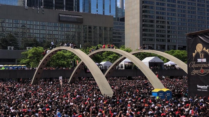 Des partisans des Raptors installés sur les structures de la place Nathan Phillips pour célébrer leurs champions.
