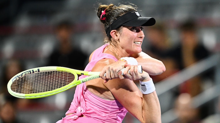 Une joueuse de tennis frappe un revers.