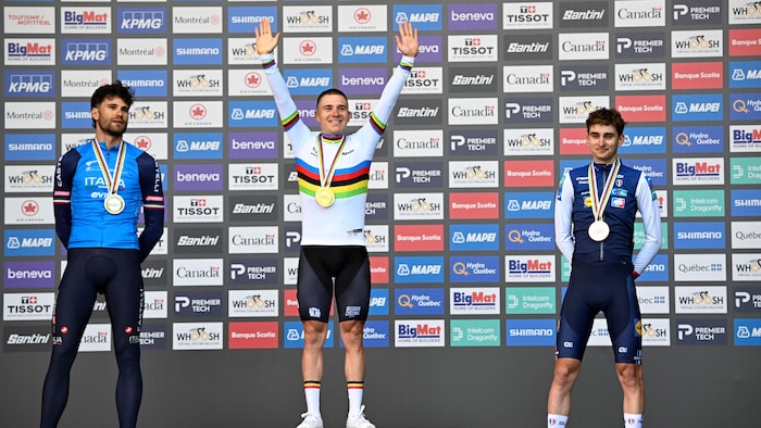 Les trois cyclistes sont sur le podium, médaille au cou.