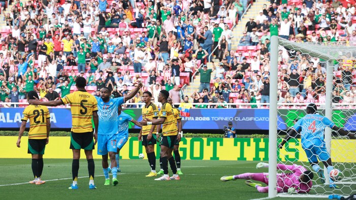 Des joueurs de soccer célèbrent un but marqué pendant un match éliminatoire.