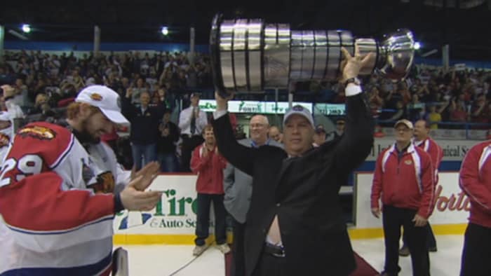 Robert Irving soulevant la coupe du Président entouré de membres de l'équipe des Wildcats. 