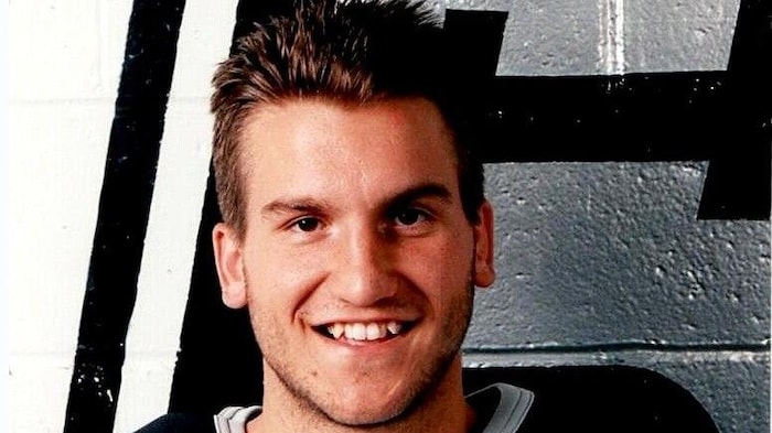 Un joueur de hockey prend la pose pour sa photo d'équipe.