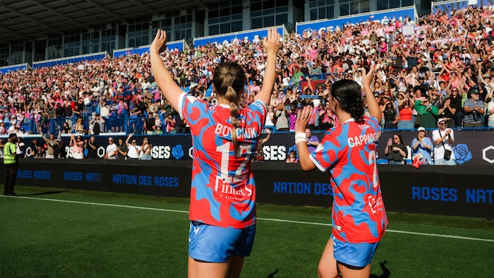 Deux joueuses de soccer saluent la foule.