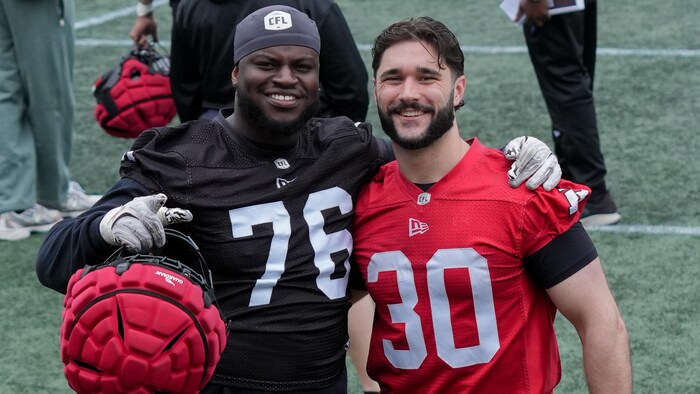 Deux joueurs de football prennent la pose pour la caméra pendant un entraînement.