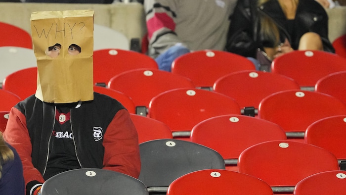 Un partisan du Rouge et Noir d'Ottawa avec un sac brun sur la tête.