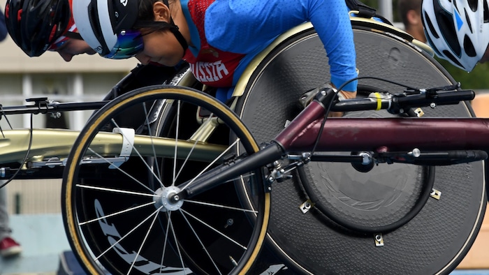 Un athlète russe en fauteuil roulant fait tourner sa roue pendant une course.