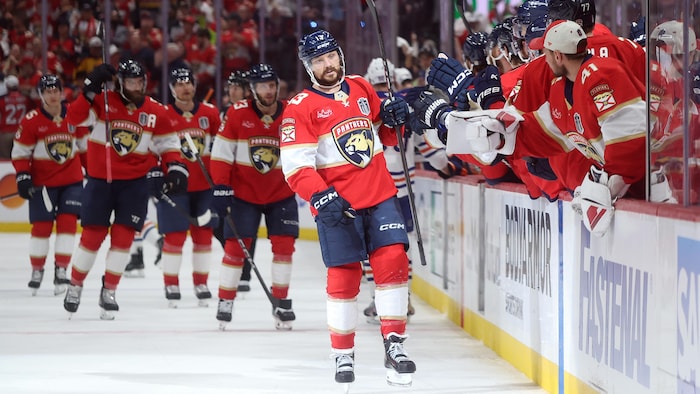 Un hockeyeur célèbre un but avec des coéquipiers.