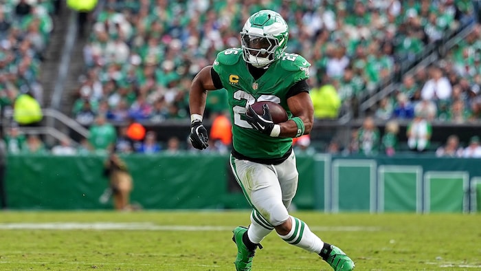 Un joueur de football court avec le ballon.