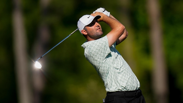 Un golfeur termine son élan. 