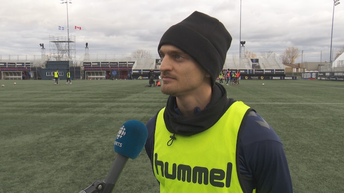 Un joueur de soccer parle à un micro.