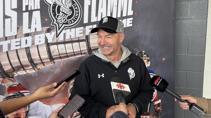Un entraîneur de hockey s'adresse aux médias. 