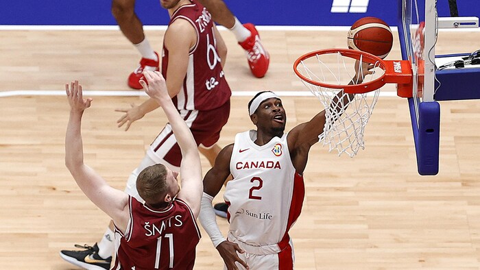 Shai Gilgeous-Alexander saute pour déposer le ballon dans le panier adverse pendant un match Canada-Lettonie. 