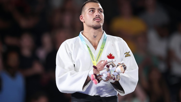 Un judoka avec sa médaille d'or au cou.
