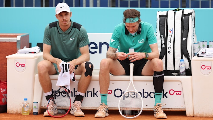 Deux joueurs de tennis sont assis sur un banc.